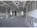 Unfinished living room featuring bare concrete floors, drywall and multiple windows at 22113 Amberbush Ct., Mount Dora, FL 32757
