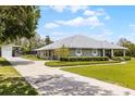 Landscaped home with well maintained lawn, long drive way and open metal garage at 23203 Outback Ln, Eustis, FL 32736