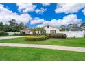 Charming single-story home featuring a manicured lawn, decorative shrubbery, and a welcoming facade with brown shutters at 275 Tollgate Trl, Longwood, FL 32750