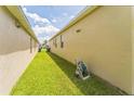 Side yard view shows green space and the exterior of the house with clean lines and windows at 2815 Shelburne Way, St Cloud, FL 34772