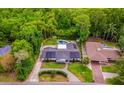 Beautiful aerial view showcases a home with solar panels, pool, a well-manicured lawn, and surrounded by lush trees at 3011 Temple Trl, Winter Park, FL 32789