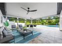 Relaxing outdoor patio features comfortable seating, ceiling fans, and views of the pool and lush backyard at 3011 Temple Trl, Winter Park, FL 32789