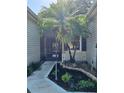 Inviting screened entrance features a beautiful palm tree, stone mulch beds, and a paver walkway at 3700 Plantation Blvd, Leesburg, FL 34748