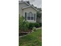 Well-maintained front yard featuring verdant foliage, flowering plants, and a manicured lawn at 3700 Plantation Blvd, Leesburg, FL 34748