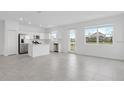 Open-concept kitchen with white cabinetry, stainless steel appliances, a center island, and easy access to the living area at 502 Bogey Dr, Davenport, FL 33896