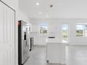 Bright, airy kitchen featuring white cabinets, stainless steel appliances, a center island, and an abundance of natural light at 502 Bogey Dr, Davenport, FL 33896