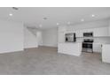 Spacious living room showcasing an open floor plan with tile flooring, recessed lighting, and kitchen access at 502 Bogey Dr, Davenport, FL 33896