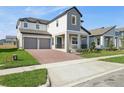 Attractive home boasts a brick driveway, a two-car garage, and neat landscaping at 5242 Citrus Leaf, Winter Garden, FL 34787
