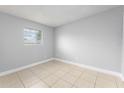 Cozy bedroom with tile floors, light gray walls, and a window with blinds at 5325 Curry Ford Rd # G202, Orlando, FL 32812