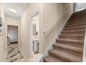 Inviting foyer with tiled floor, stairs, and access to a half-bath with pedestal sink at 7349 Ella Ln, Windermere, FL 34786