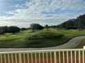 Scenic view of a lush green golf course with rolling hills and trees under a partly cloudy sky at 7518 Seven Eagles Way # 201, Reunion, FL 34747