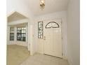 Bright entryway featuring tile flooring, a decorative front door with stained glass, and an archway to another room at 7703 Pine Vista Ct, Orlando, FL 32819