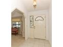 Bright foyer featuring tile flooring, a decorative stained-glass window, and an adjacent living area at 7703 Pine Vista Ct, Orlando, FL 32819