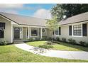 Landscaped front yard with a curved walkway leading to the charming front door with decorative glass at 7703 Pine Vista Ct, Orlando, FL 32819