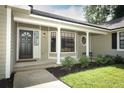 Welcoming front porch with columns, a decorative front door, and neatly trimmed landscaping at 7703 Pine Vista Ct, Orlando, FL 32819
