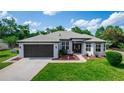 Charming single-story home featuring a well-manicured lawn, gray roof, and attached two-car garage at 825 White Birch Ct, Orange City, FL 32763
