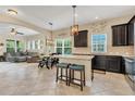 Open-concept kitchen with granite countertops, dark cabinetry, stainless steel appliances, and a breakfast bar perfect for entertaining at 8679 Laureate Blvd, Orlando, FL 32827