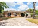 Lovely single-story home with brick and siding, plus a brick driveway and lots of trees at 100 Crestwood Dr, Longwood, FL 32779