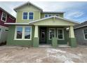 Two story house with a light green exterior, a covered porch and ample windows at 10043 Dulbecco St, Orlando, FL 32827