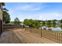 Large wooden deck overlooking a serene lake with mature trees and fenced backyard at 1103 Saddleback Ridge Rd, Apopka, FL 32703