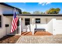 Inviting front porch with brick flooring, a bench, and the American flag displayed, enhancing the home's patriotic charm at 1231 Glastonberry Rd, Maitland, FL 32751