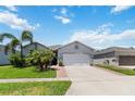 Attractive home with a well-kept lawn, mature palm trees, and a spacious driveway for easy parking at 12335 Sumter Dr, Orlando, FL 32824
