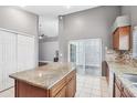 Spacious kitchen island with granite countertops, white tile floors, and stainless steel dishwasher at 143 Abbey Hollow Dr, Apopka, FL 32712