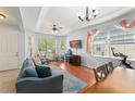 Bright and airy living room with large windows, wood floors, a ceiling fan, and a cozy seating area at 14537 Cheever St, Orlando, FL 32828