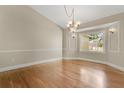 Inviting dining room featuring hardwood floors, neutral walls, with picture-frame moulding and a modern chandelier at 1512 Adriatic Dr, Ocoee, FL 34761