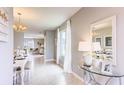 Stylishly designed dining area with an elegant chandelier, large mirror, and open view to living area at 194 Amberwood Way, Umatilla, FL 32784