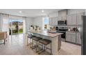 Open kitchen featuring an island with seating, modern appliances, and sliding glass doors at 2052 Monteverde Ave, Davenport, FL 33837