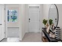 Well-lit entryway showcasing a neutral color palette, stylish decor on a console table, and a welcoming front door at 207 Taylor Groves Dr, Lake Wales, FL 33898