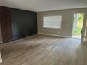 Modern living room with wood-look tile flooring, natural light, and decorative wall accents at 225 W 2Nd St, Chuluota, FL 32766