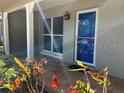 Inviting tiled front porch with vibrant flowers, complemented by a blue-trimmed door and adjacent window at 2886 Carew Ave, Winter Park, FL 32789