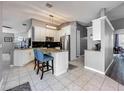Modern kitchen with white cabinetry, stainless steel appliances, granite countertops, and a stylish kitchen island with seating at 38241 County Road 439, Eustis, FL 32736