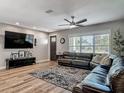 Inviting living room featuring a comfortable sofa, entertainment center, and natural light from the window at 39 Lake Dr, Debary, FL 32713