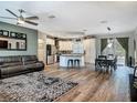 Spacious living room with ceiling fan, dining table, kitchen island, and access to outdoor living area at 39 Lake Dr, Debary, FL 32713