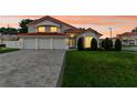 Charming two-story home with three-car garage and manicured lawn at sunset at 3904 Woodsfield Ct, Orlando, FL 32822