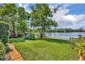 Lush backyard with manicured lawn gently sloping to the lake waters edge at 3960 Lake Mira Dr Dr, Orlando, FL 32817