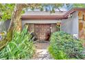 Inviting front entrance with a tiled walkway leading to a double-door entry, complemented by lush landscaping at 3960 Lake Mira Dr Dr, Orlando, FL 32817