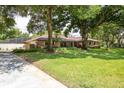 Well-maintained brick house with lush green lawn, mature trees, and long driveway at 429 Kimberly Ct, Sanford, FL 32771