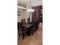 Dining room with an elegant chandelier, a dark wood table, and windows with striped curtains at 4920 E Lake Cove Blvd, St Cloud, FL 34771