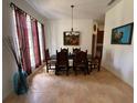 Spacious dining room with tile floors, large window, and elegant light fixture at 4920 E Lake Cove Blvd, St Cloud, FL 34771
