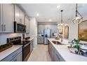 Modern kitchen featuring stainless appliances, grey cabinetry and a large kitchen island at 540 Southern Edge Way, Sanford, FL 32771