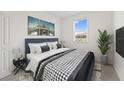 Comfortable bedroom showcasing a queen bed with stylish bedding, modern art and a bright window at 555 Southern Edge Way, Sanford, FL 32771