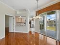 Bright living area featuring hardwood floors, a view to the kitchen, and sliding doors to the balcony at 7021 Della Dr # 51, Orlando, FL 32819