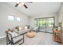 Open living room with neutral tones, ceiling fan, and sliding glass doors to a screened-in porch at 711 Swan Ln, Altamonte Springs, FL 32701
