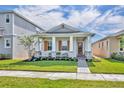 Inviting single-story home featuring a well-maintained lawn, a covered front porch, and stone detailing at 744 Yukon Ln, Debary, FL 32713