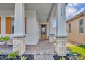 Welcoming front porch with stone columns, brick pavers, and a modern front door, creating a stylish entrance at 744 Yukon Ln, Debary, FL 32713
