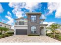 Beautiful two-story home featuring stone accents, manicured landscaping, and a spacious driveway at 7905 Jacks Club Dr, Kissimmee, FL 34747